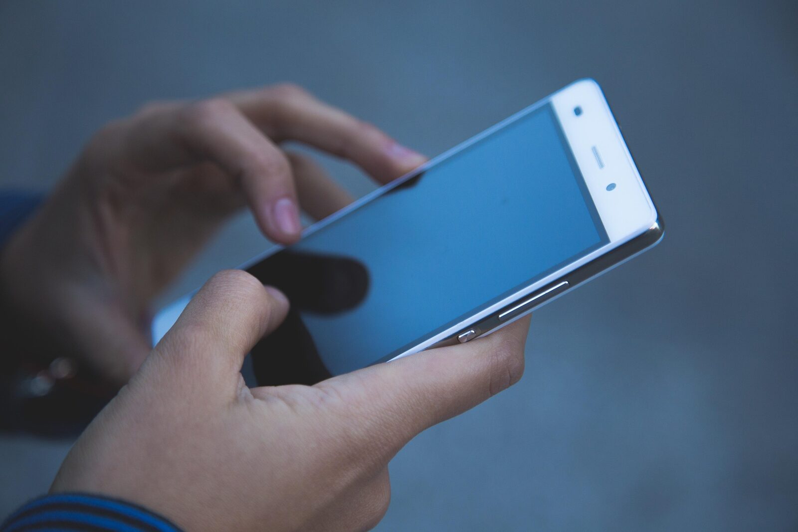 Hands holding and using a smartphone